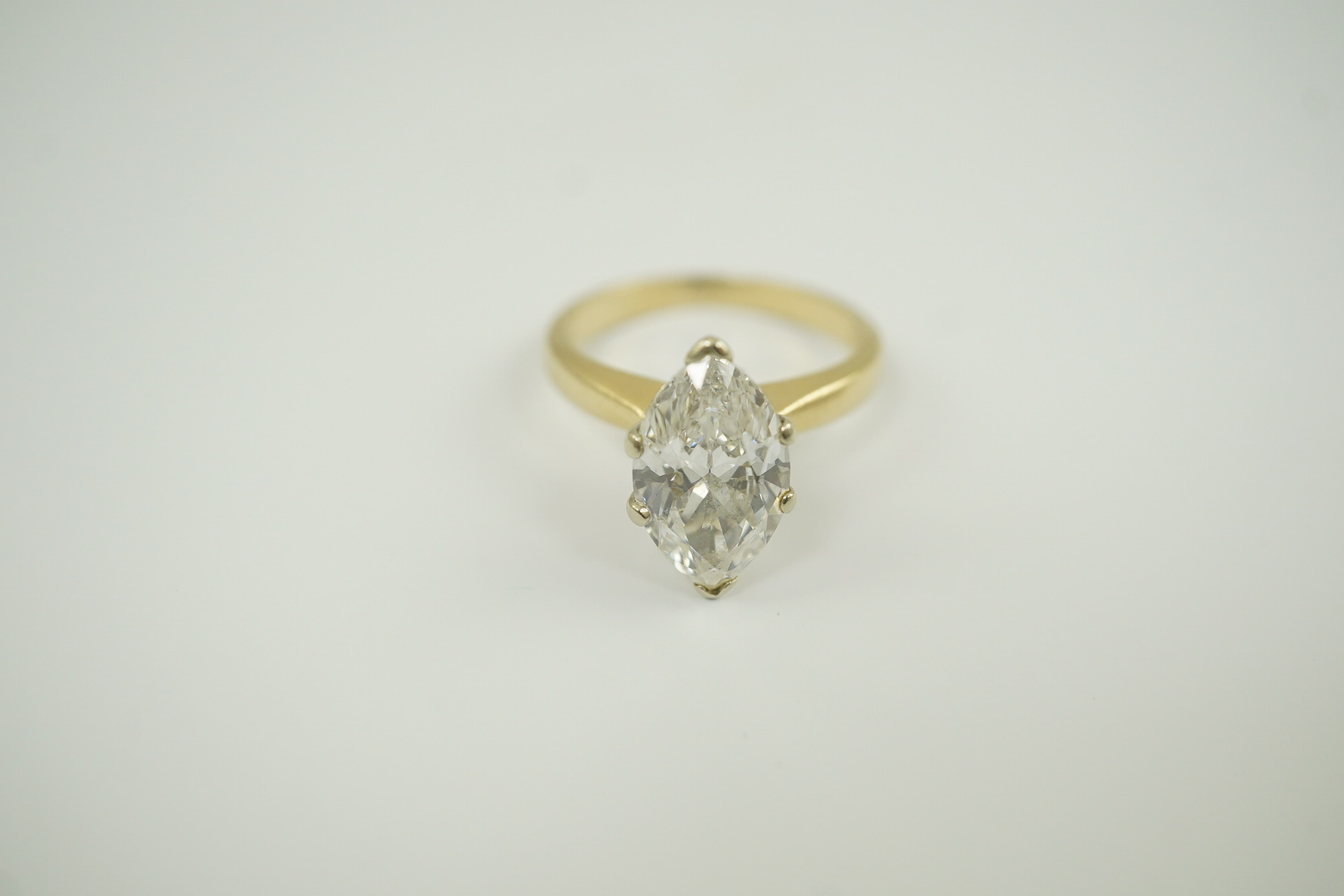 A modern 14k gold and solitaire marquise diamond set ring